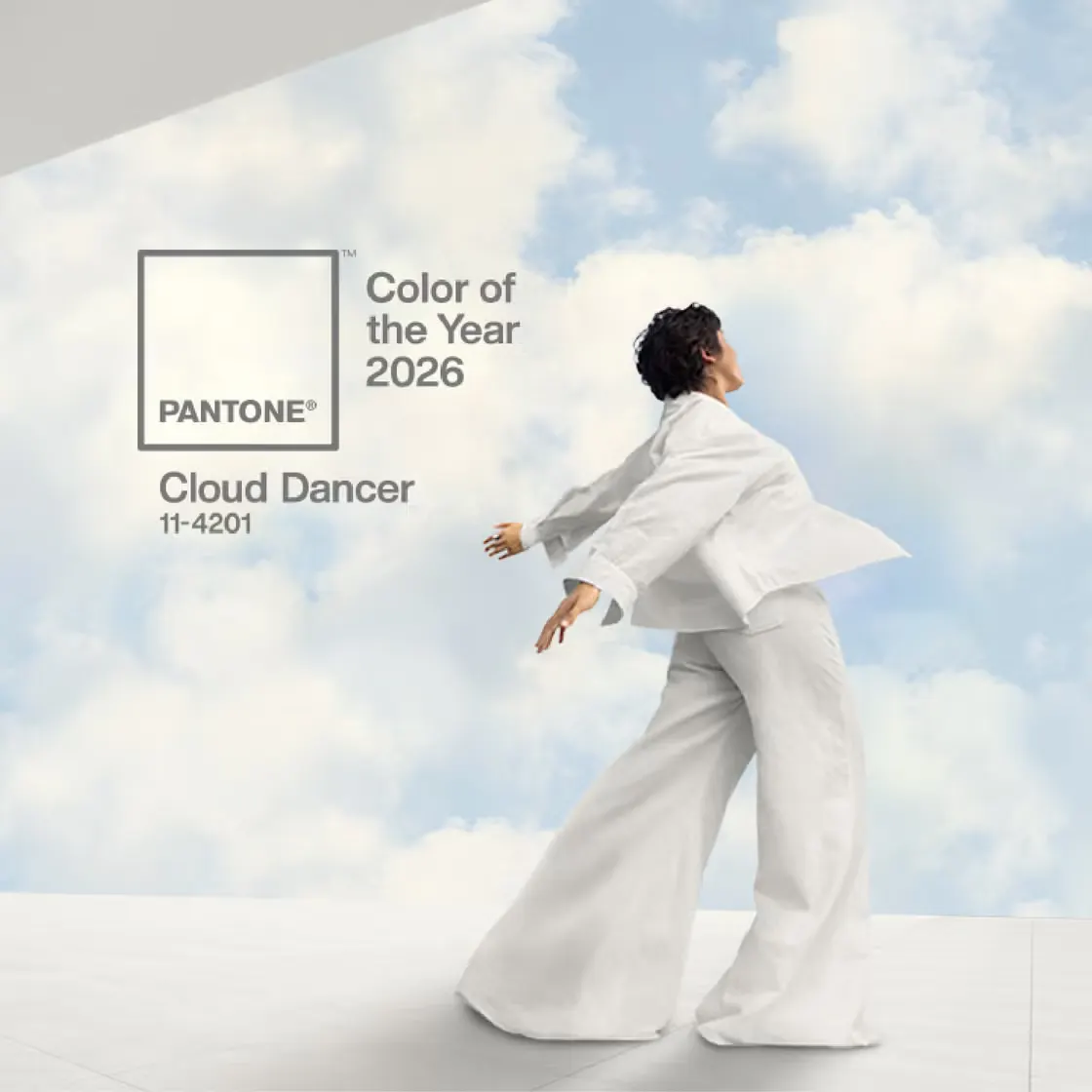 Visual del Pantone Color of the Year 2026 Cloud Dancer: a sinistra campione di colore bianco caldo con logo Pantone, a destra donna vestita di bianco che si muove davanti a un cielo azzurro con nuvole e box con scritta ‘Color of the Year 2026 – Cloud Dancer 11-4201
