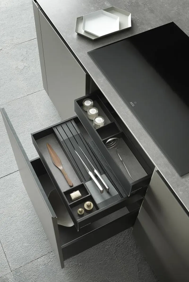 Cassettiera di un'isola per cucina grigia con utensili